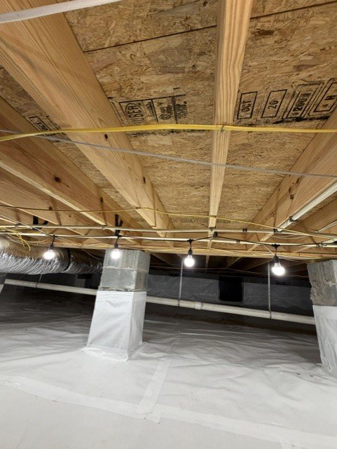 Encapsulated crawlspace with vapor barrier, support posts, and HVAC ducts