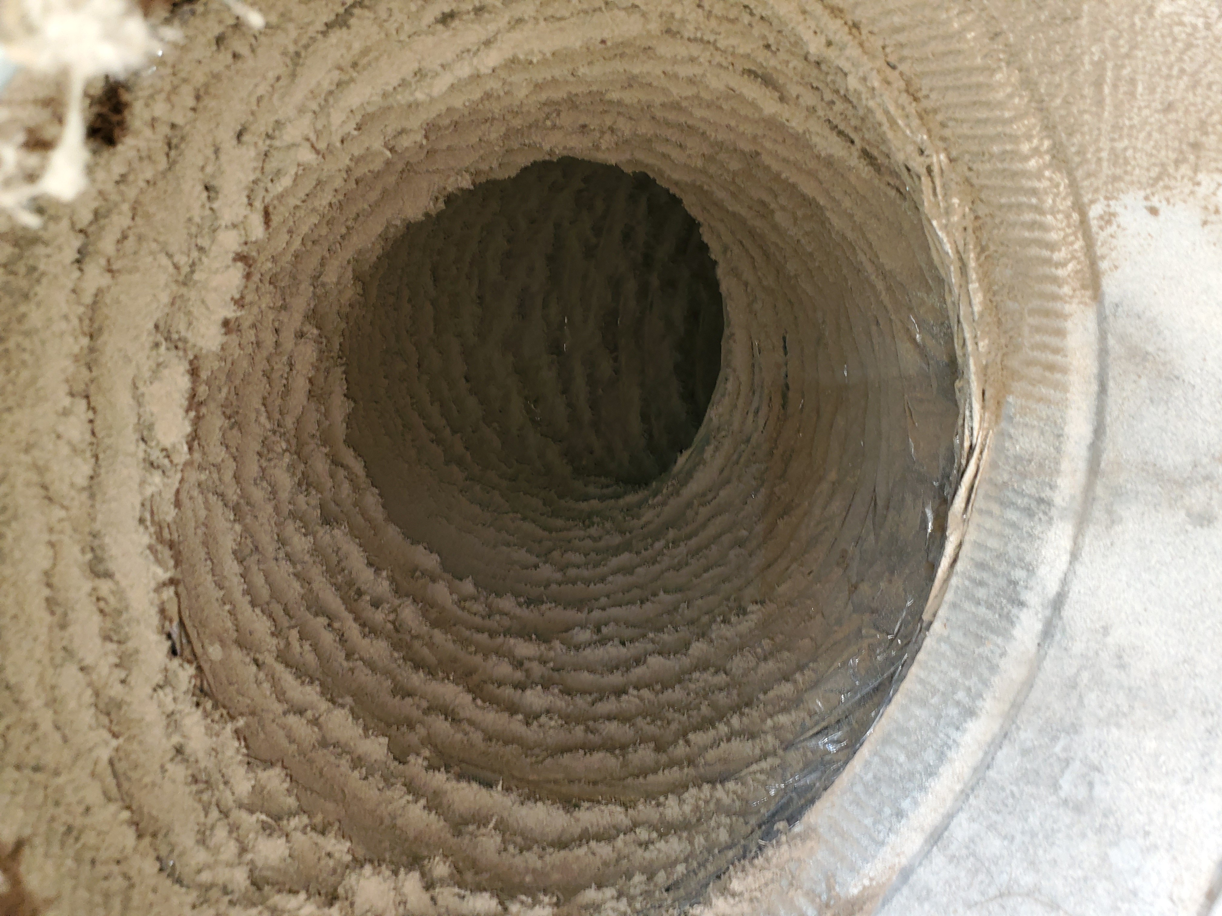 Interior of air duct with visible dust and debris buildup before cleaning service