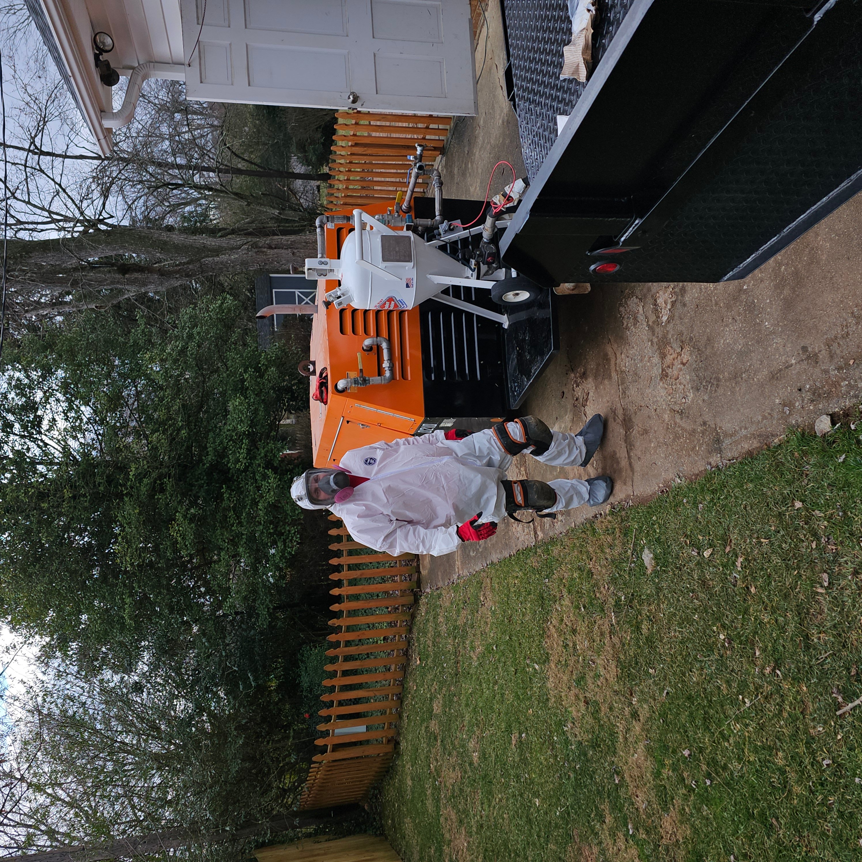 Technician with truck-mounted air duct cleaning equipment at residential home