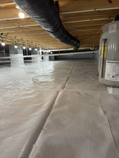 Crawlspace with white vapor barrier encapsulation and black ductwork installed