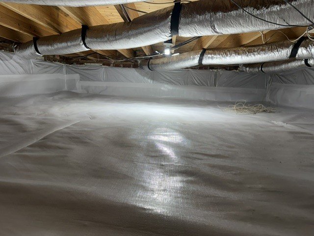 Crawlspace with white vapor barrier and wrapped HVAC ducts installed