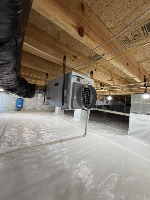 Encapsulated crawlspace with vapor barrier, dehumidifier unit, and HVAC ductwork