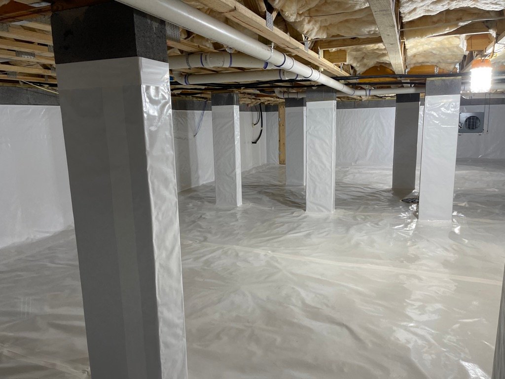 Crawlspace with white vapor barrier, sealed support posts, and HVAC ductwork installation